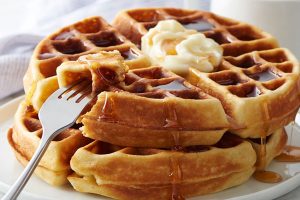 large plate of waffles with syrup, butter, and fork from breakfast restaurant in The Wildwoods NJ