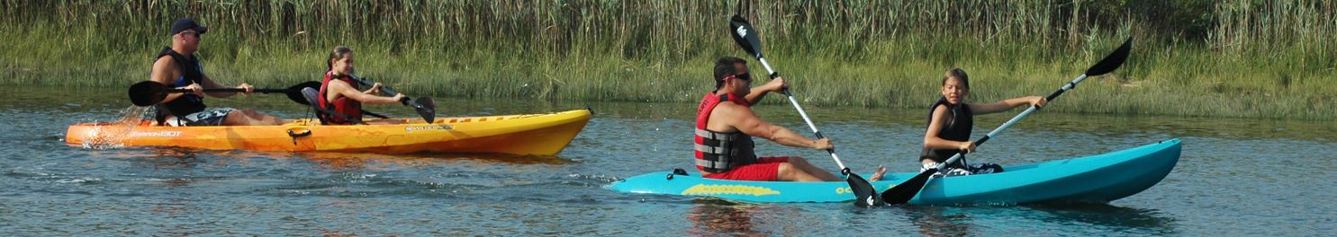 group of people paddling in kayaks and canoes down water in Wildwood NJ