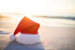 red and white santa hat sitting on sand at the beach in the Wildwoods NJ