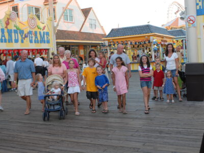 Family with parents and children walking along the boardwalk in Wildwoods NJ