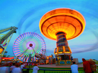 A carnival ride spins and glows in the evening at the Wildwoods Boardwalk.