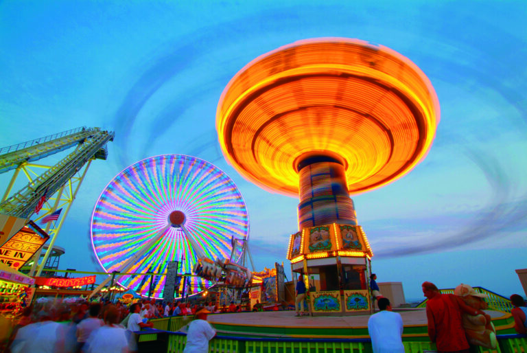 A carnival ride spins and glows in the evening at the Wildwoods Boardwalk.