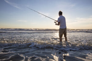 A man casts his fishing rod in the waters of the Wildwoods Beach.