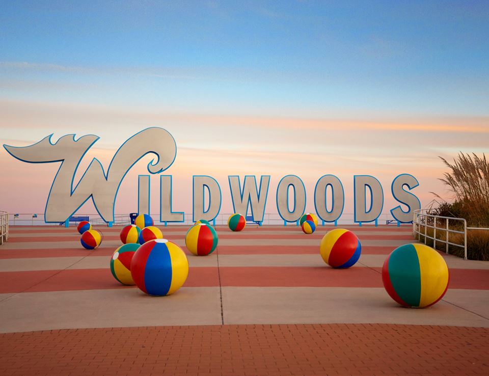 The Wildwoods Sign with an array of beach balls at sunset.