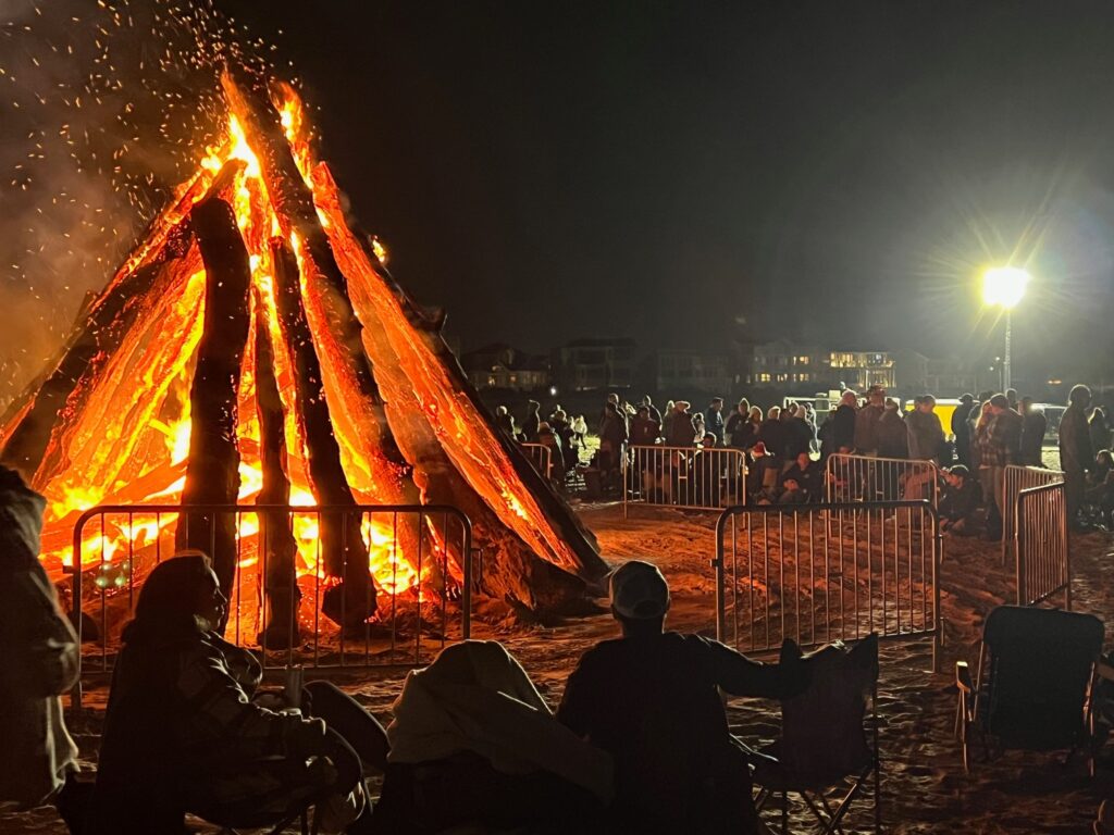 group enjoying a large Holiday Bonfire set up on the beach in The Wildwoods NJ